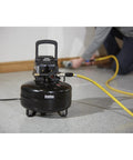 Portable 3 Gallon Air Compressor 0.3 HP 110 PSI Max Pressure Oil Free Pump in use for DIY tasks with yellow hose.
