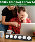 Wooden Golf Ball Display Case Black Wall Mount Holder Shelf For Collectors shown on table with couple in background