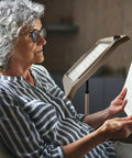 Senior woman reading with Bronze Floor Magnifier Lamp With 8x10 Inch Shade 3x Magnification Built In LED Lighting Full Page View.