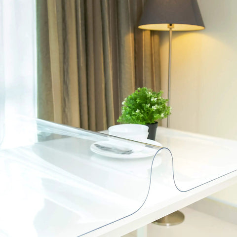 Clear Plastic Table Cover Protector 60x36 Inches Vinyl Tabletop Shield on dining table with lamp and plant in background.
