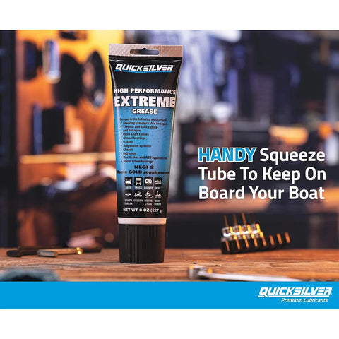 Front view of Quicksilver 8 oz High Performance Extreme Marine Grease tube with blue and black label on a workbench.
