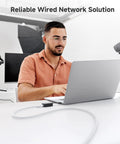 Man using laptop with 10Gbps Snagless Cat6 Ethernet Cable 5ft Multi Color Set for Fast LAN Connections, office setting