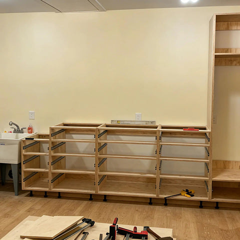 Cabinets supported by adjustable leveler feet 3.9 to 5 inches, 12 pack black plastic furniture levelers, in unfinished kitchen setup.
