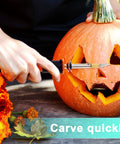 Side view of an electric hot knife cutter with orange handle carving a jack-o-lantern pumpkin