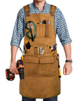 Man wearing Tough As Nails 20 Oz Waxed Canvas Woodworking Apron For Men With 9 Tool Pockets, holding a drill, showing khaki color.