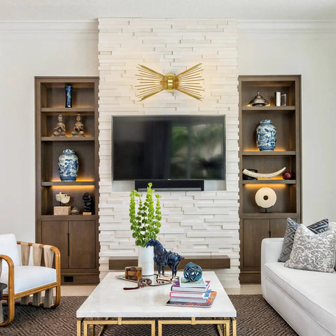 Living room with antique brass two light modern mid century wall sconce above flat-panel TV on stone feature wall.