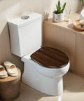 Elongated walnut wood wood grains pictures Toilet Seat on a modern white toilet with decorative bathroom elements.