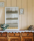 Wooden dresser with matte black cabinet knobs under a framed mirror and decor, showcasing home makeover style.