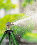 Two Pack 360 Degree Rotary Lawn Sprinklers On Metal Tripod Bases With Adjustable Height spraying water on lawn