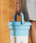 Person carrying Compact Portable Mini Washing Machine Foldable Washer With Spin Dryer Bucket for travel and home use