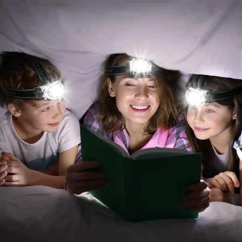 Family reading under a blanket using Five Pack LED Headlamps With 8 LEDs Four Lighting Modes Pivoting Head Adjustable Strap