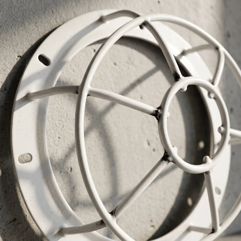 Close-up of Tough As Nails Smoke Sensor Protective Cage, white polypropylene, mounted on wall, ideal for fire alarm sprinkler protection.