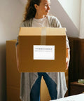 Person holding a box with a Self Adhesive Packing List Envelopes With Window Design Large Capacity Plastic Document Envelopes attached.