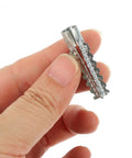 Close-up of a hand holding a serrated metal drywall anchor from the Heavy Duty Steel Hollow Wall Anchors With Screws Kit for Drywall and Plaster Walls.