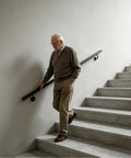 Heavy Duty Wall Mounted Stair Handrail Stainless Steel Black Finish Built Like A Tank With Dang Solid Grip And Top Notch Durability For Indoor Staircases Rated Up To Two Hundred Pounds Legit Quality, elderly man using handrail on stairs.
