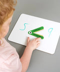Child using Greater Than Or Less Than Gator Mouth Math Manipulatives Set Of 12 For Grades K 3 Ages 5 8 to compare numbers on a whiteboard
