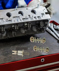 Heavy Duty Brake Adjustment Tool Kit With Metal Hold Down Springs And Pins For Drum Brakes In Construction Machinery, Beefed Up Friction Stability, Quick Spring Tool For Fast Stops, And Easier Loader Disc Brake Access. Metal brake spring and pins on workbench