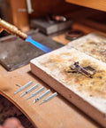 Top Tier Copper Soldering Iron Tips 5 Pack With High Thermal Conductivity And Wear Resistance For Pro Welding Or DIY Projects Plus User Friendly Design That Gets The Job Done Quick And Smooth with a flame and soldering tips on a workbench.