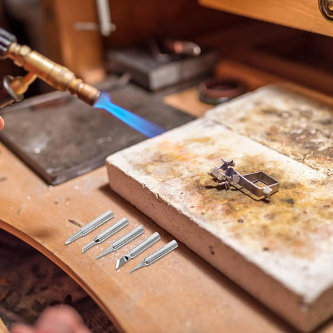 Top Tier Copper Soldering Iron Tips 5 Pack With High Thermal Conductivity And Wear Resistance For Pro Welding Or DIY Projects Plus User Friendly Design That Gets The Job Done Quick And Smooth with a flame and soldering tips on a workbench.