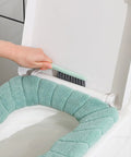 Using angled bowl brush from 4 In 1 Toilet Brush And Plunger Set In Green, cleaning under toilet seat rim with compact scrubber.