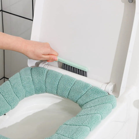 Using angled bowl brush from 4 In 1 Toilet Brush And Plunger Set In Green, cleaning under toilet seat rim with compact scrubber.