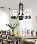 Five Light Matte Black Farmhouse Industrial Chandelier With Clear Glass Shades in dining room setting above table