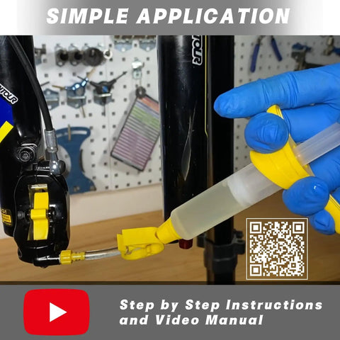 Person using DOT 5.1 Hydraulic Brake Fluid syringe on bike disc brake system