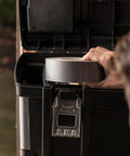 Duct tape roll, silver, 1.88 in width, being applied to a black outdoor storage box.