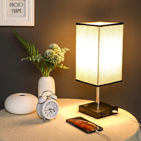 Black Nightstand Lamps 2 Pack with Touch Dimming AC Outlet and Dual USB Ports Fabric Shade Bedside Lamps, lit on table