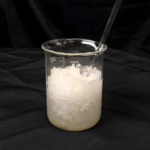 Liquid Lock Slurry Absorbent Powder in a beaker solidifying liquid waste for safe transport and disposal, high absorption capacity.