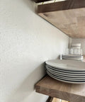 Heavy Duty Floating Shelf Brackets Fifty Eight Inches Long Invisible Mantel Supports For Thick Lumber Boards Matte Black Alloy Wall Mount Holders displaying white plates on a wood shelf.