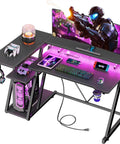 40 Inch L Shaped Gaming Desk With Power Outlet And LED Lights Carbon Fiber Textured Corner Computer Desk With 3 Tier Storage Shelves And Monitor Stand, featuring gaming setup with accessories and RGB lighting
