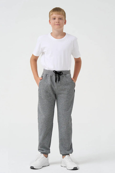 Boy wearing grey joggers with a drawstring, part of Three Pack Boys Sweatpants Fleece Joggers With Zipper Pockets Cozy Everyday Lounge And Gym Class Ready