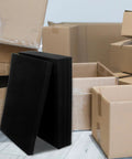 4 Pack Black Polyurethane Foam Packing Blocks For Shipping And Storage next to cardboard boxes, ideal for cushioning glassware and ceramics.