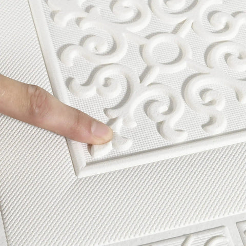 Close-up of finger touching 3D Peel And Stick Wall Panels Set 9 Pieces Covers 35 Sq Ft White Ceiling And Wall Decor texture.