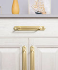 7.56 Inch Cabinet Handles In Brushed Brass installed on a white cabinet, showing sleek design with backplate and solid zinc alloy material.