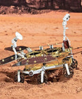 Space Rover 281+ Piece STEM Mechanical Explorer Puzzle Kit For Adults And Gearheads, DIY Aerospace Model For Home Desk Display, Educational Building Project Gift With Realistic Wheels, Antennas, And Discovery Detail. Metal space rover model on sandy terrain with wheels, antennas, and solar panels
