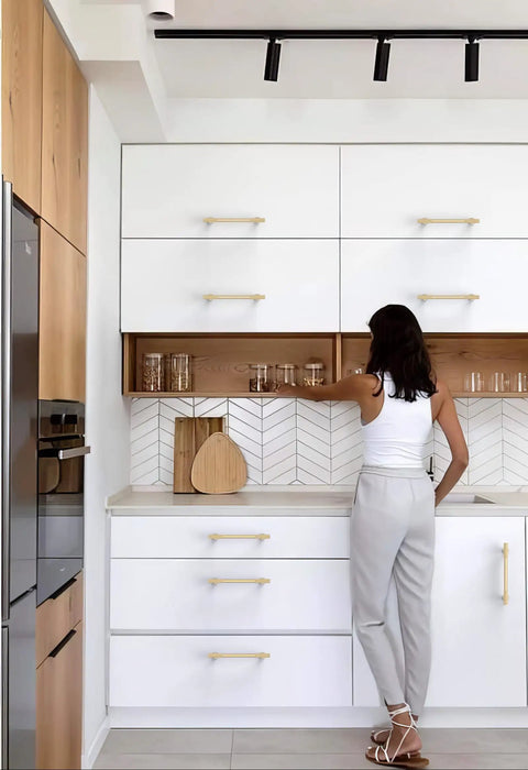 Woman using Pro Grade Brushed Gold Cabinet Pulls And Drawer Handles 5 Inch Center To Center Kitchen Hardware in modern kitchen.