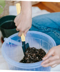 Person using wooden garden tool handles pack of five for weeding and mowing multipurpose replacement grips in soil bucket.