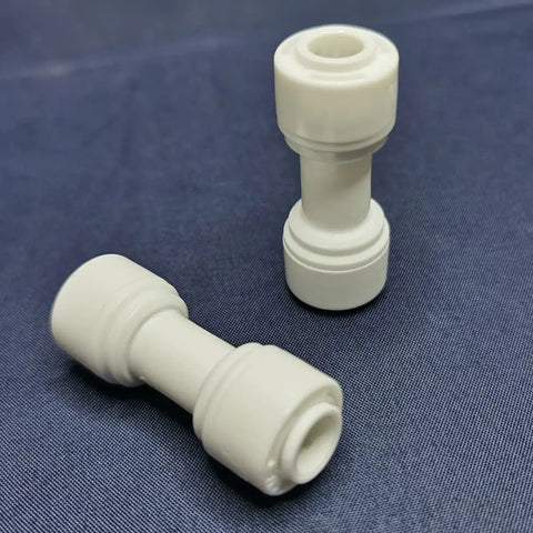 Water Purifier Straight Union Connector One Quarter Inch OD Tube Quick Push To Connect Fitting Made For Residential RO DI Water Filter Systems Durable Plastic Plumbing Connector Pack Of 100, two connectors on a dark background.