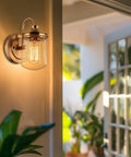 Wall-mounted sconce with seed glass shade on patio