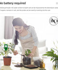 Woman using 5X Mini Soil Moisture Meter With Light And PH Tester for Quick Garden Care with indoor plants on table.