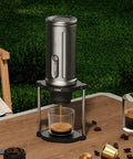Proven Travel Espresso Stand And Universal Coffee Maker Rack With No Sweat Assembly For Drip Brewers And Portable Grinder Kits That Keeps Your Morning Brew Routine Fully Locked In, silver portable espresso maker on wooden table.