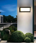 Outdoor Wall Light Modern Exterior Sconce 3000K Warm Waterproof Rectangular Porch Lighting 2 Pack 30W For Patio Garage Front Door Porch Vibes Great For Curb Appeal, mounted on a white wall at night.