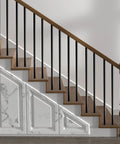 Straight Up Premium Aluminum Deck Balusters 51 Pack, 36 Inch Round Stair Spindles mounted on wooden staircase.