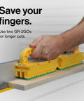 Side view of two yellow GRR-RIPPER 2GO push blocks with green base on a wood strip beside a table saw