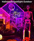 Halloween display with 12W RGB Low Voltage Landscape Lights With RF Remote illuminating a giant skeleton and spiderweb on a house
