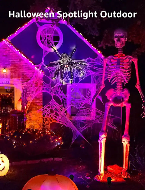 Halloween display with 12W RGB Low Voltage Landscape Lights With RF Remote illuminating a giant skeleton and spiderweb on a house