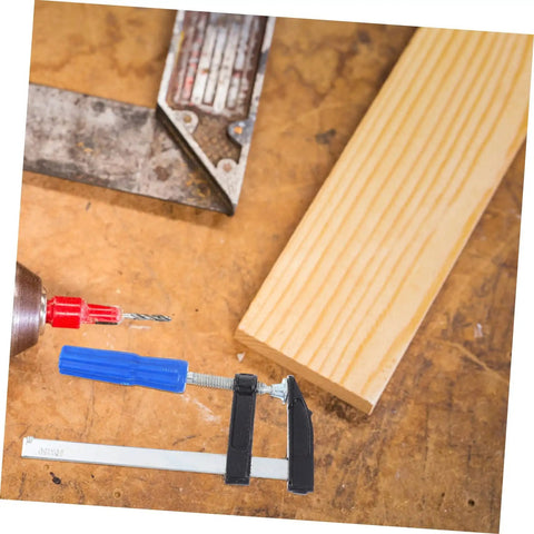 Four Pack Woodworking Clamps Durable Spring Fixing Tools with beefy grip on a workbench with wood and drill for DIY projects
