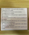 Cardboard box with multilingual warning label advising adult supervision for usage.